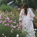 Woman in a silk kimono standing in a field of flowers with a mountainous background