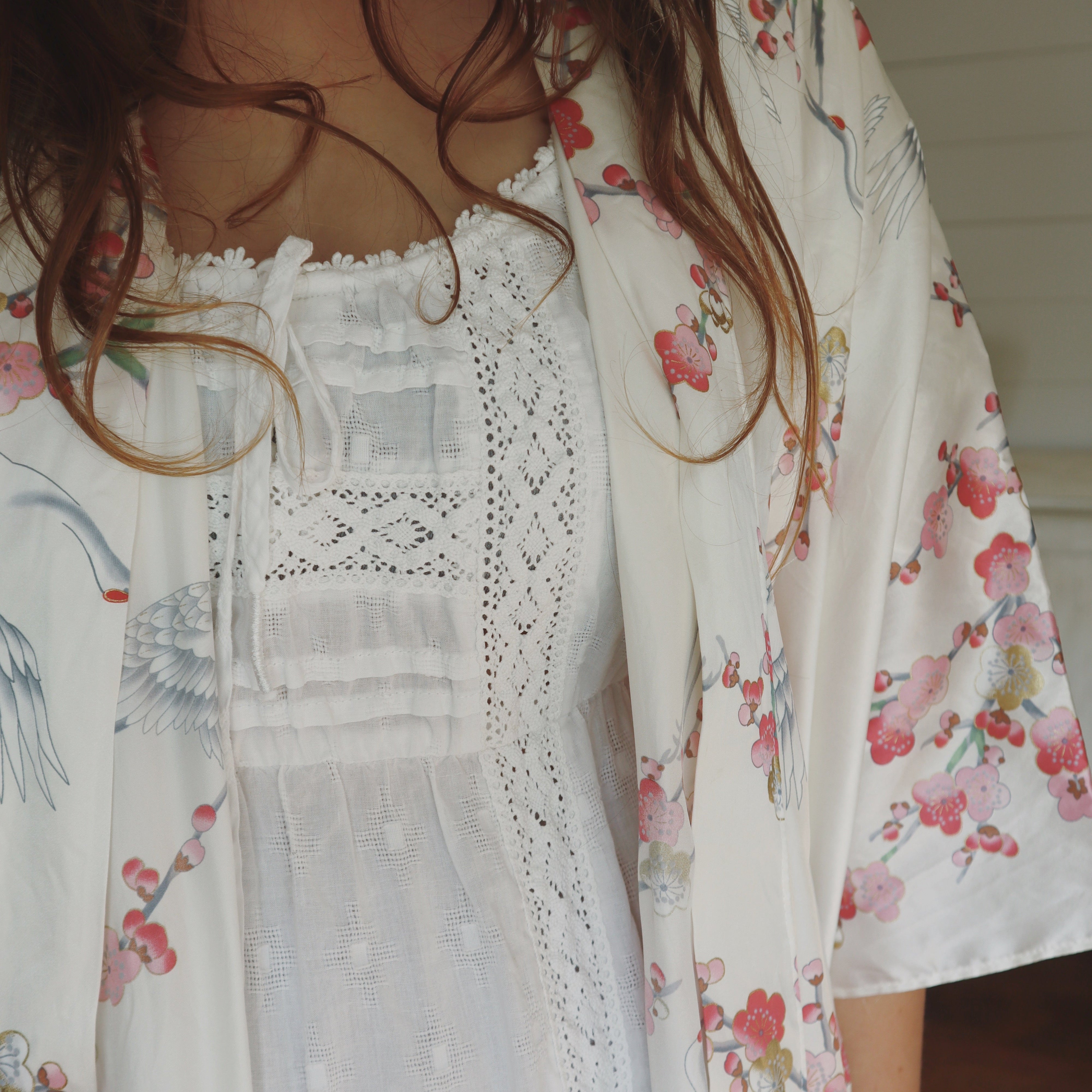 Floral kimono with lace nightie worn by a person, blurred background