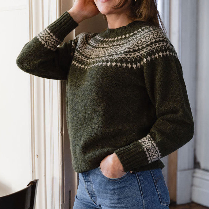 Person wearing a green fair isle knit sweater indoors