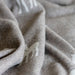 Close-up of textured beige wool blanket with a subtle pattern.