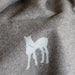 Close-up of nutmeg wool blanket with a white foal motif.