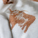 White fabric with brown cow print pattern