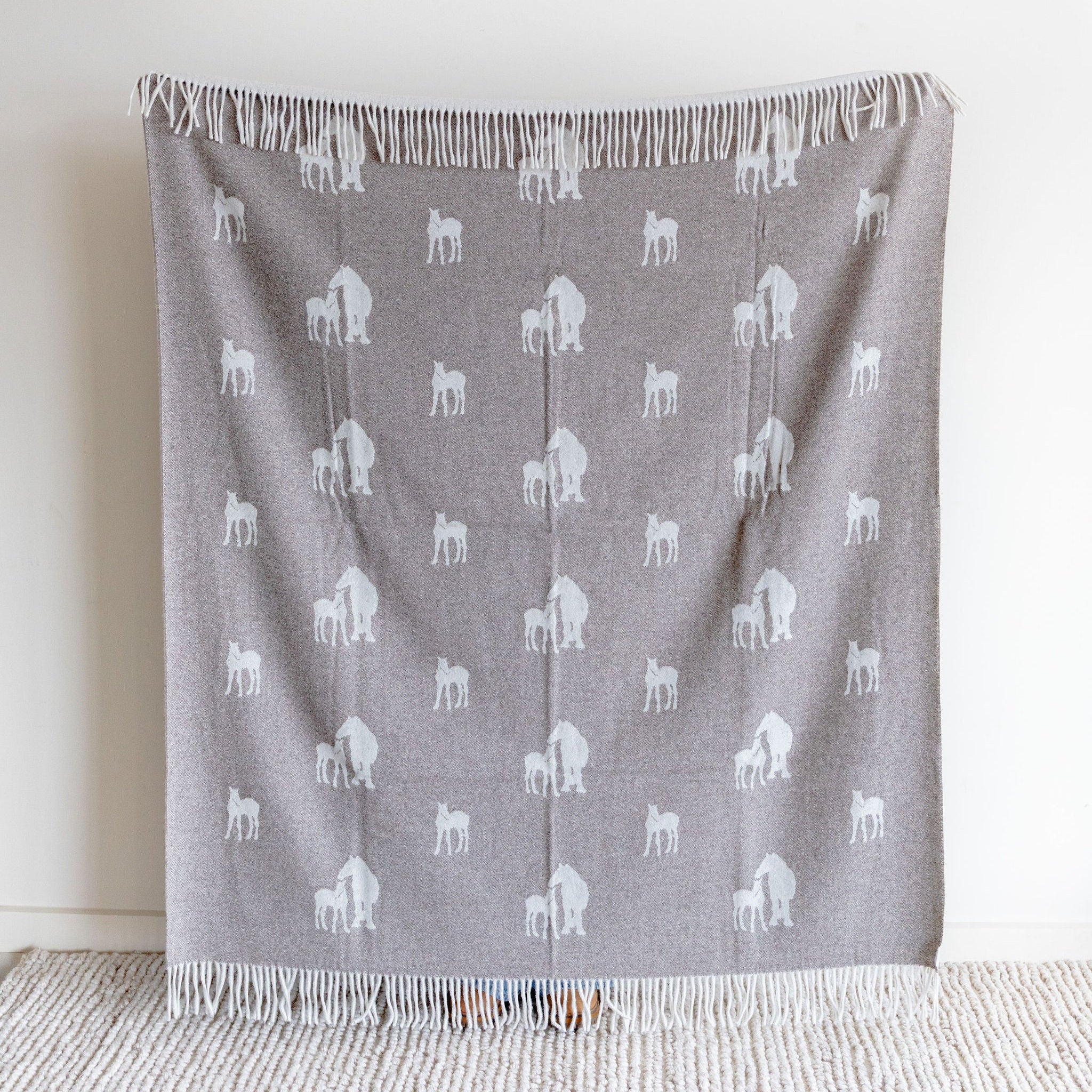 Wool blanket with white horse pattern on a light nutmeg background