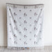 Blanket with horse pattern draped over a chair against a white wall