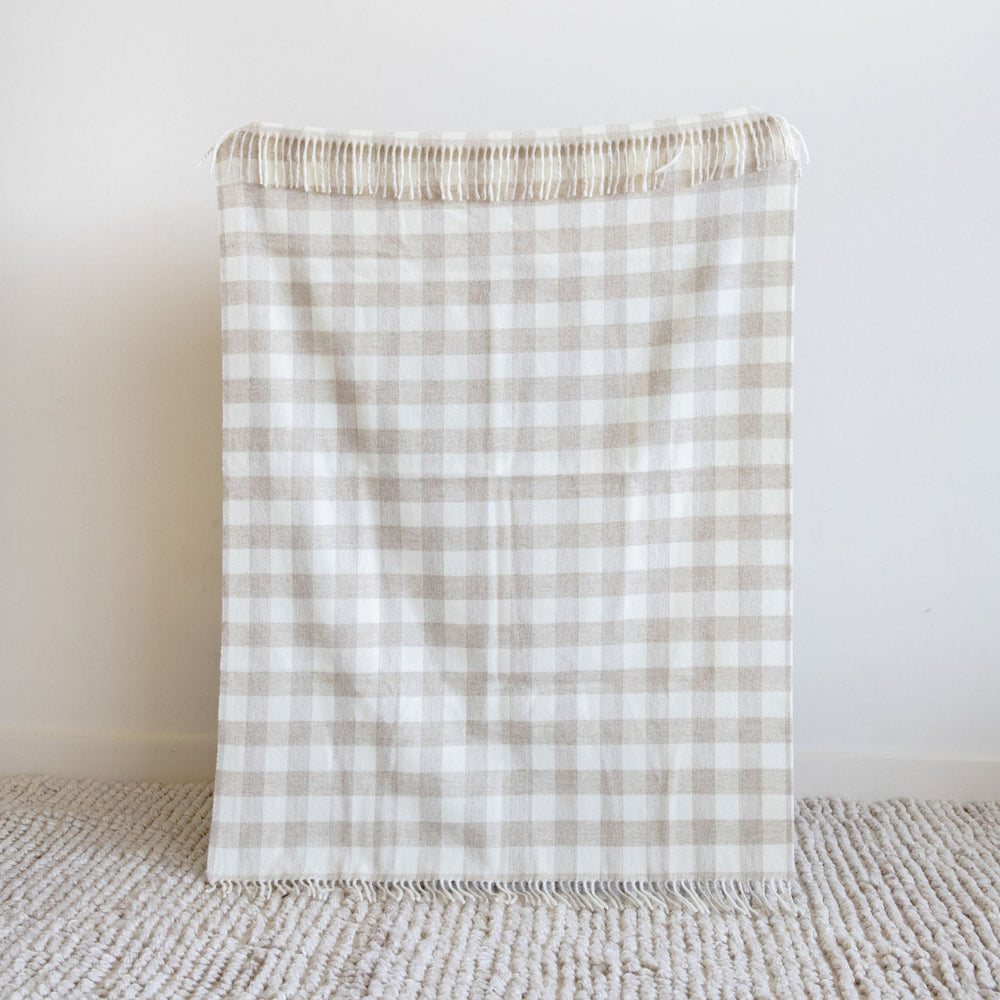 Plaid blanket on a textured surface with a light background