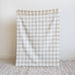 Plaid blanket on a textured surface with a light background