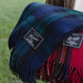 Plaid blanket with brand labels held by a person in a field