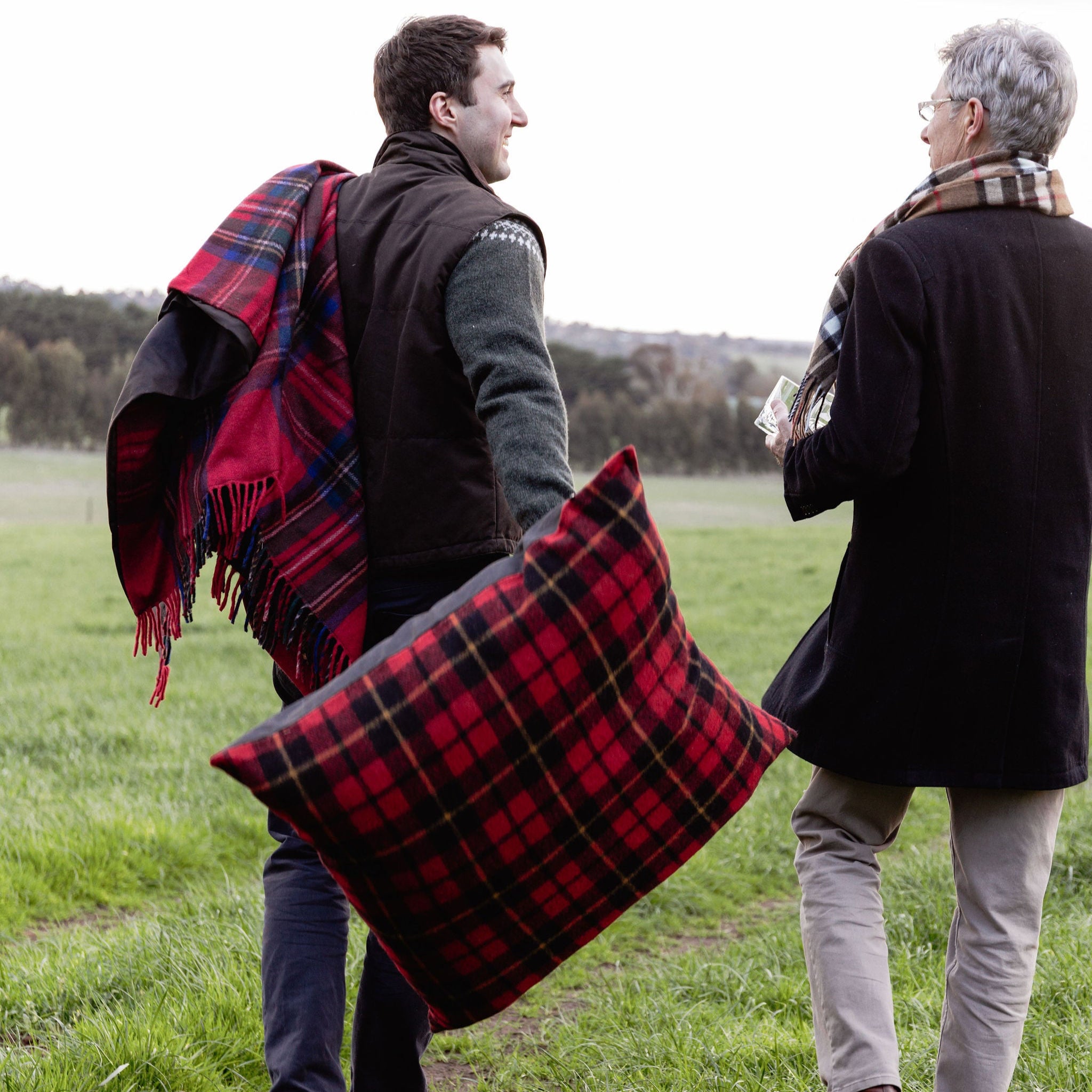 Two people in a field with plaid blankets