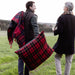Two people in a field with plaid blankets