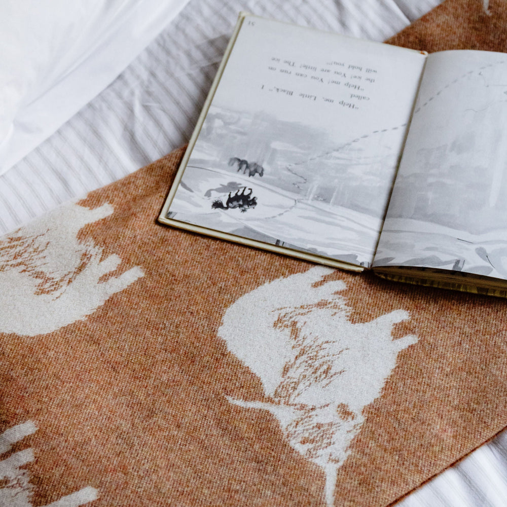 Open book on a world map with a teddy bear on a white surface