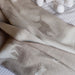 Folded beige blanket with animal pattern on a white surface