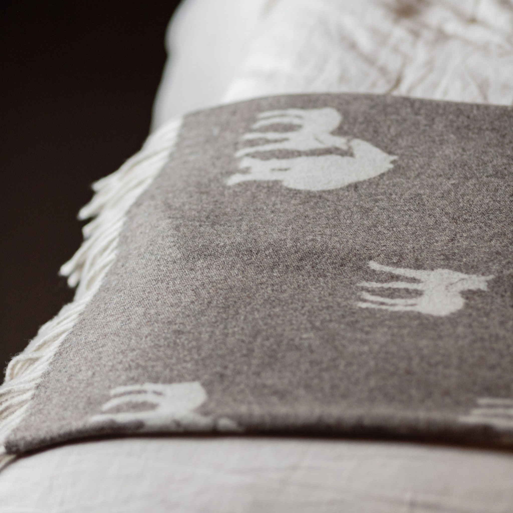Gray pillow with white patterns on a textured surface