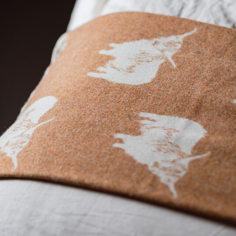 Close-up of a quilt with white floral patterns on a brown background