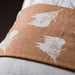 Close-up of a quilt with white floral patterns on a brown background