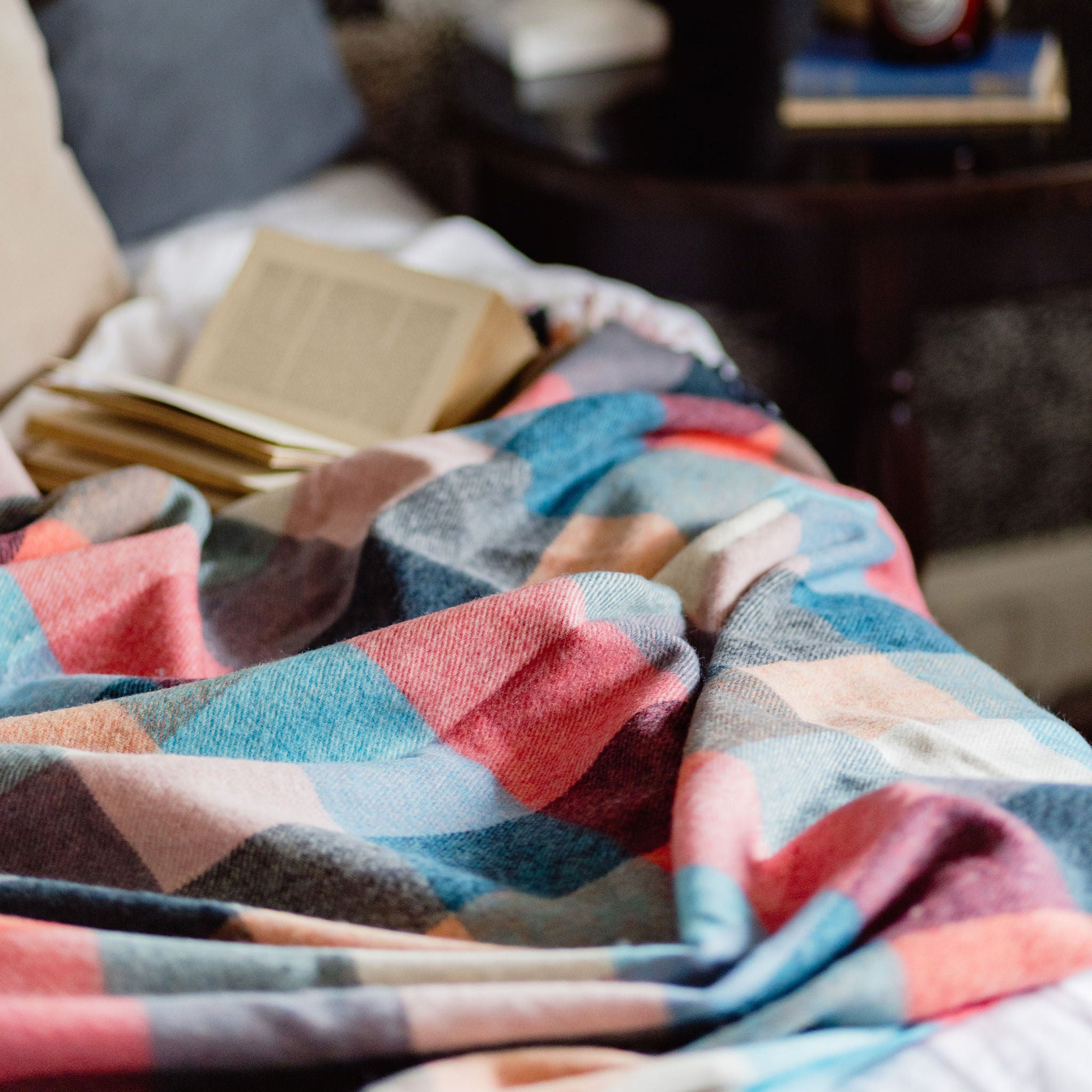 Colorful checkered blanket on a bed with a blurred background