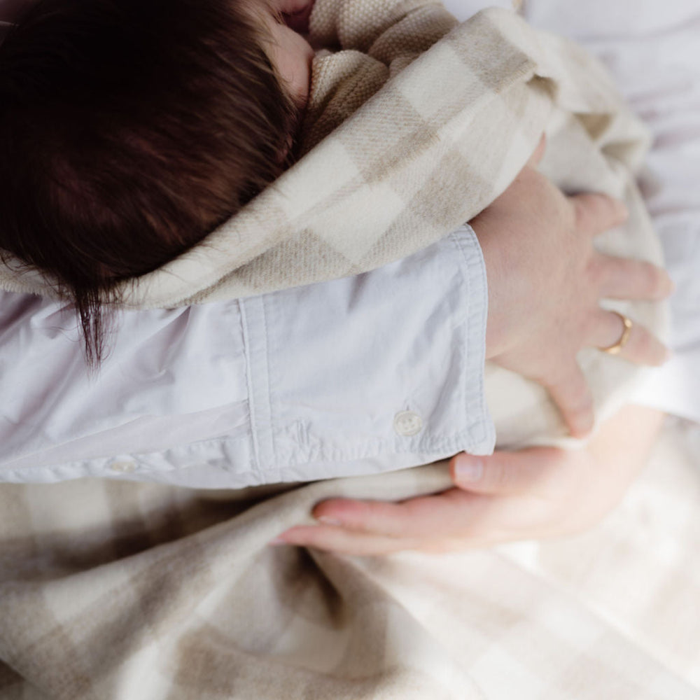 Person holding a baby wrapped in a blanket