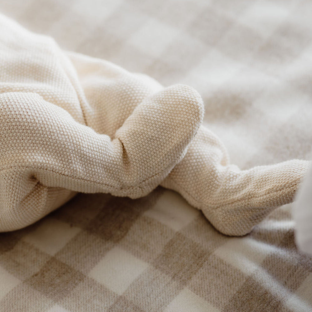Close-up of a baby's feet on a checkered blanket