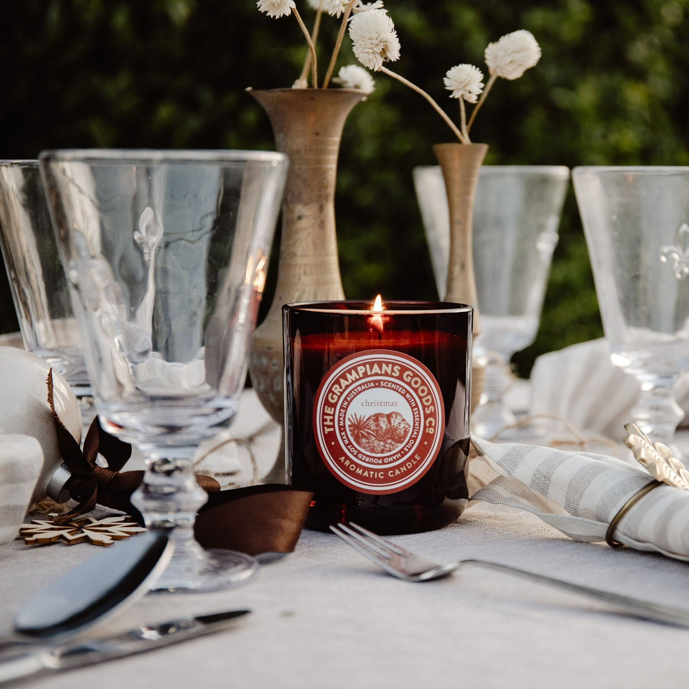 Candle with a brand label on a table setting outdoors