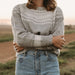 Person wearing a patterned sweater and jeans standing in a field